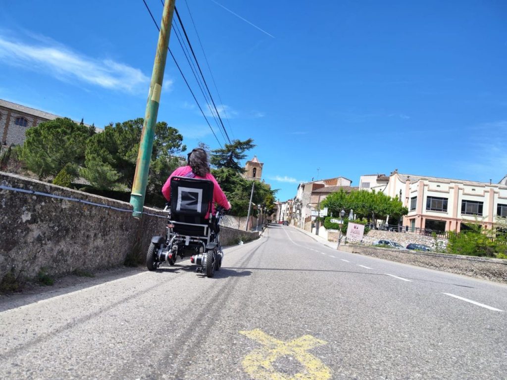 Una persona en cadira de rodes creuant el pont.